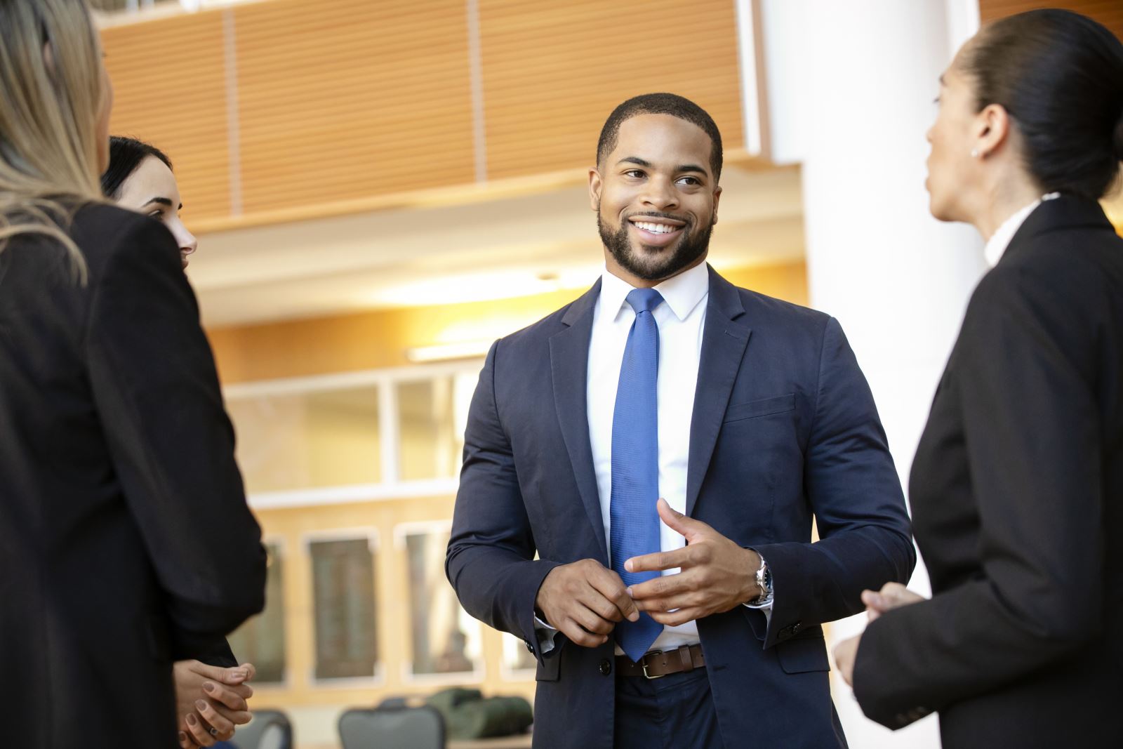 man in suit talking to workers